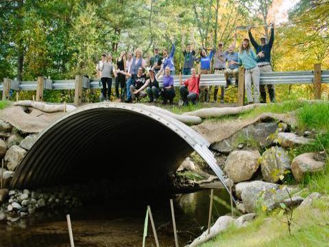 people on a stream crossing bridge